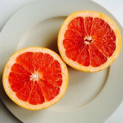 Close-up of halved grapefruits in plate