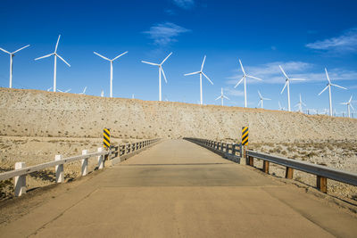 Wind turbines on land against sky