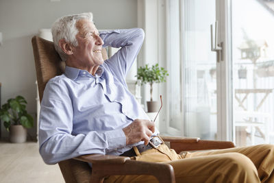 Portrait of senior man relaxing on armchair at home