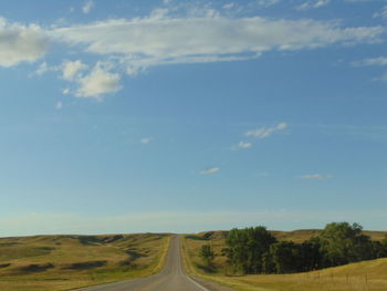 Road passing through landscape against sky