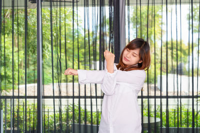 Portrait of smiling young woman standing by railing