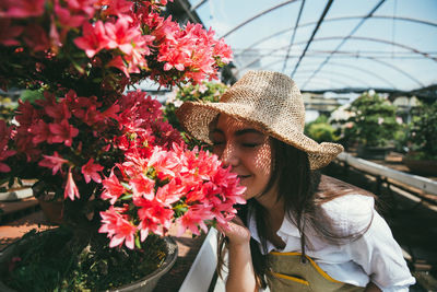 Smiling woman smelling pink flowering plant