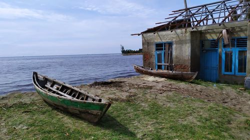 Abandoned boat moored on beach against sky