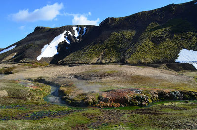 Flowing hot stream rising from a flowing hot spring in rural iceland.