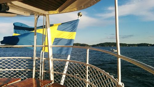 Close-up of yellow flag on sea against blue sky