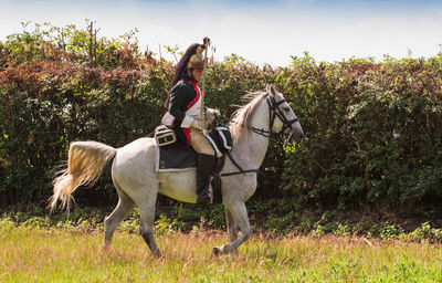 Friends riding horse on field