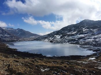 Scenic view of lake and snowcapped mountains against sky