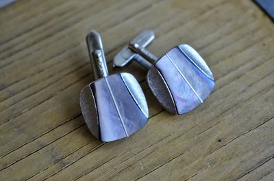 High angle view of cufflinks on wooden table