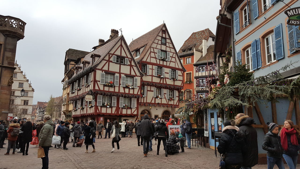 PEOPLE IN TOWN SQUARE AGAINST SKY