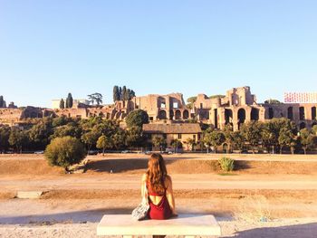 Woman overlooking ruined built structures