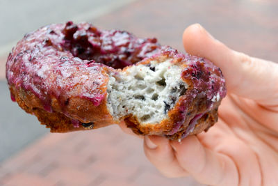 Cropped image of hand holding donut