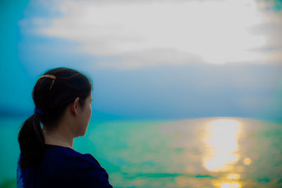 Portrait of woman looking at sea against sky