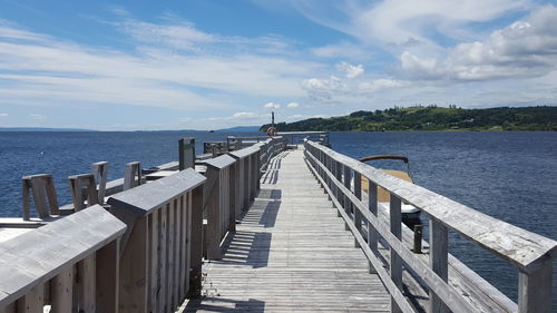 Pier over sea against cloudy sky