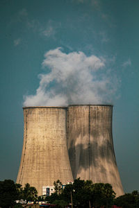 Low angle view of smoke stack against sky