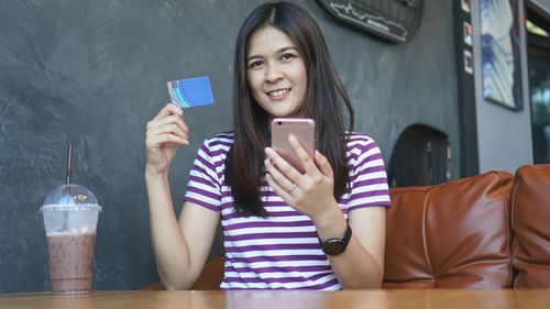 Portrait of smiling young woman using mobile phone