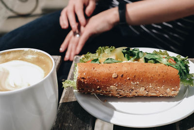 Cropped image of woman with coffee and cake