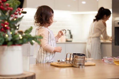 Side view of mother and daughter at home