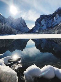 Scenic view of lake by snowcapped mountains against sky