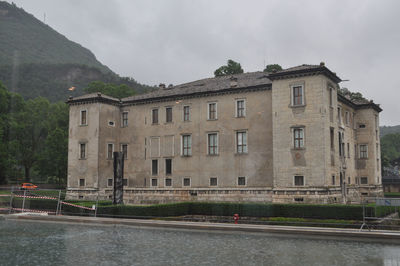 Buildings by river against sky