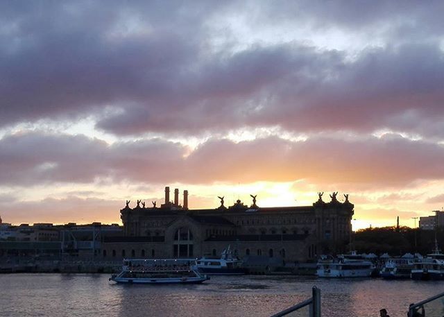 transportation, nautical vessel, mode of transport, architecture, building exterior, built structure, water, boat, sky, sunset, waterfront, moored, cloud - sky, harbor, river, city, cloudy, travel, cloud, orange color