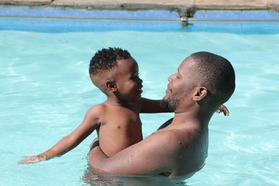 High angle view of shirtless boy in swimming pool