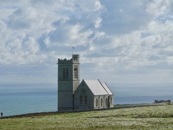 Lighthouse amidst buildings against sky