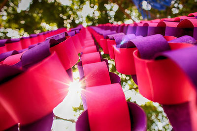 Close-up of red bell hanging against trees