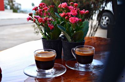 Coffee cup with black coffee by flower pots