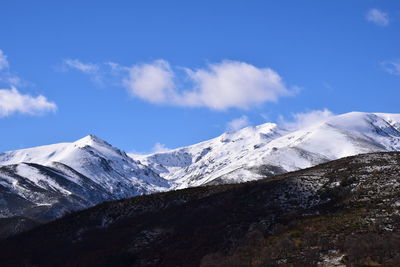 Scenic view of snowcapped mountains against blue sky