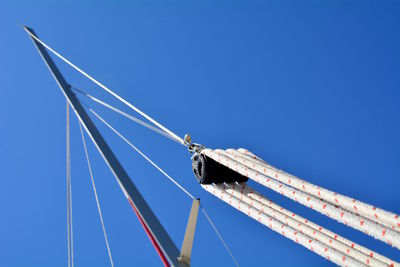 Low angle view of sailboat against clear blue sky