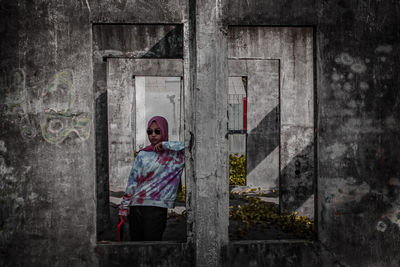 Portrait of woman standing against building