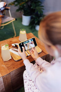 Cropped hands of woman using mobile phone