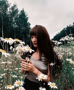 Woman standing by flowering plants