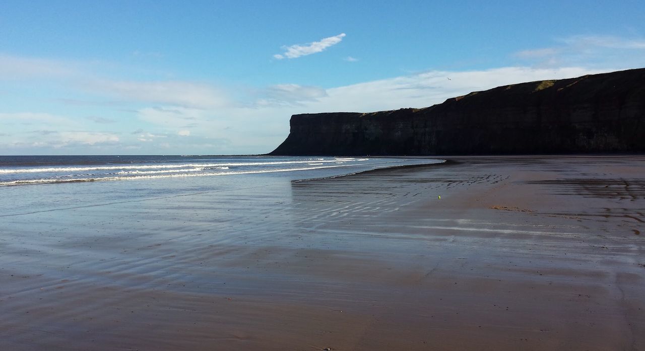 sea, beach, water, sky, sand, scenics, built structure, shore, tranquil scene, tranquility, tourism, architecture, wave, travel destinations, nature, beauty in nature, vacations, coastline, cliff, cloud, cloud - sky, blue, outdoors, tide, castle, non-urban scene, mountain, famous place, no people