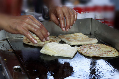 Midsection of person preparing food in kitchen