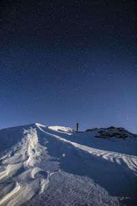 Scenic view of snowcapped mountain against sky at night