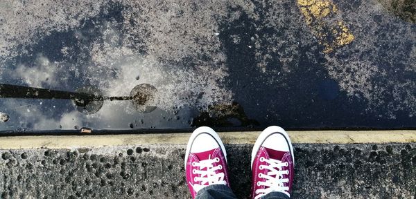 Low section of person standing by water