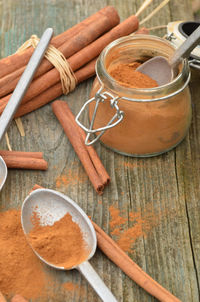 Cinnamon powder spice, cinnamon sticks, spice jar, pewter spoons,