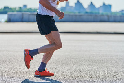 Running old man. senior man jogging in sportswear on city road. street workout, sprinting outdoor