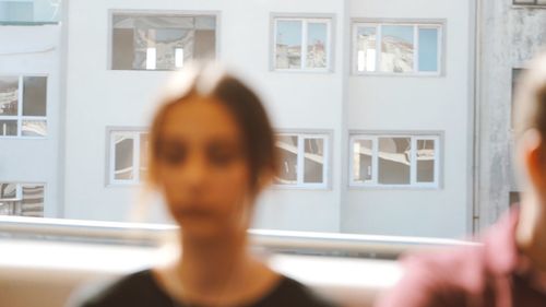 Rear view of woman seen through window