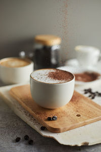 Close-up of coffee cup on cutting board