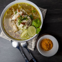 Soto ayam, indonesian food, photographed high angle view decorated with cutlery