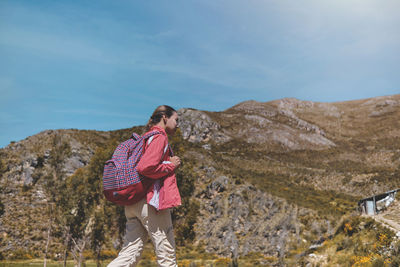 Young tourist walks on a path to the mountain. adventure travel, hiking concept