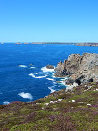 Scenic view of sea seen from cliff against sky