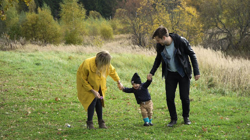 Happy young family spending time together outside in green nature.