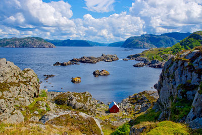 Looking down on svendsvika, a red tourist hytte, by the rocky sea