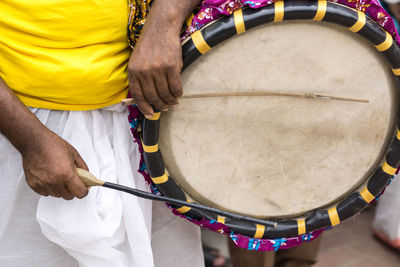 Midsection of man playing drum