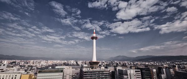 Buildings in city against cloudy sky