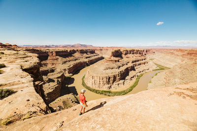Female hiker takes in the view above the green river confluence utah