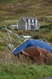 Abandoned boat and a house in the nature